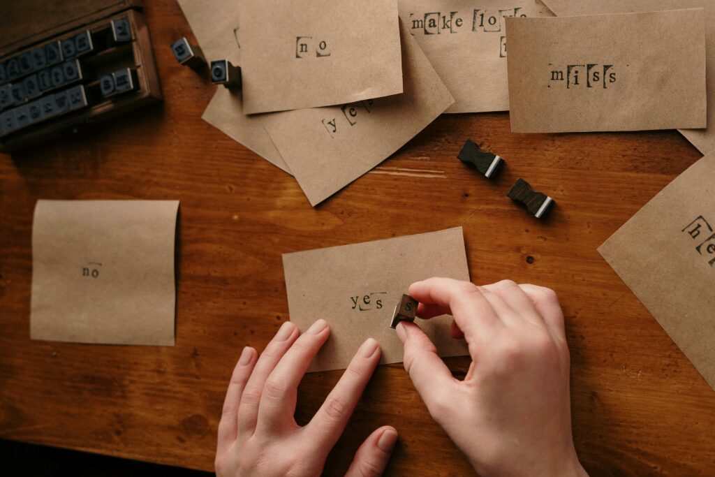 Hände, die Buchstaben auf braunes Papier stempeln